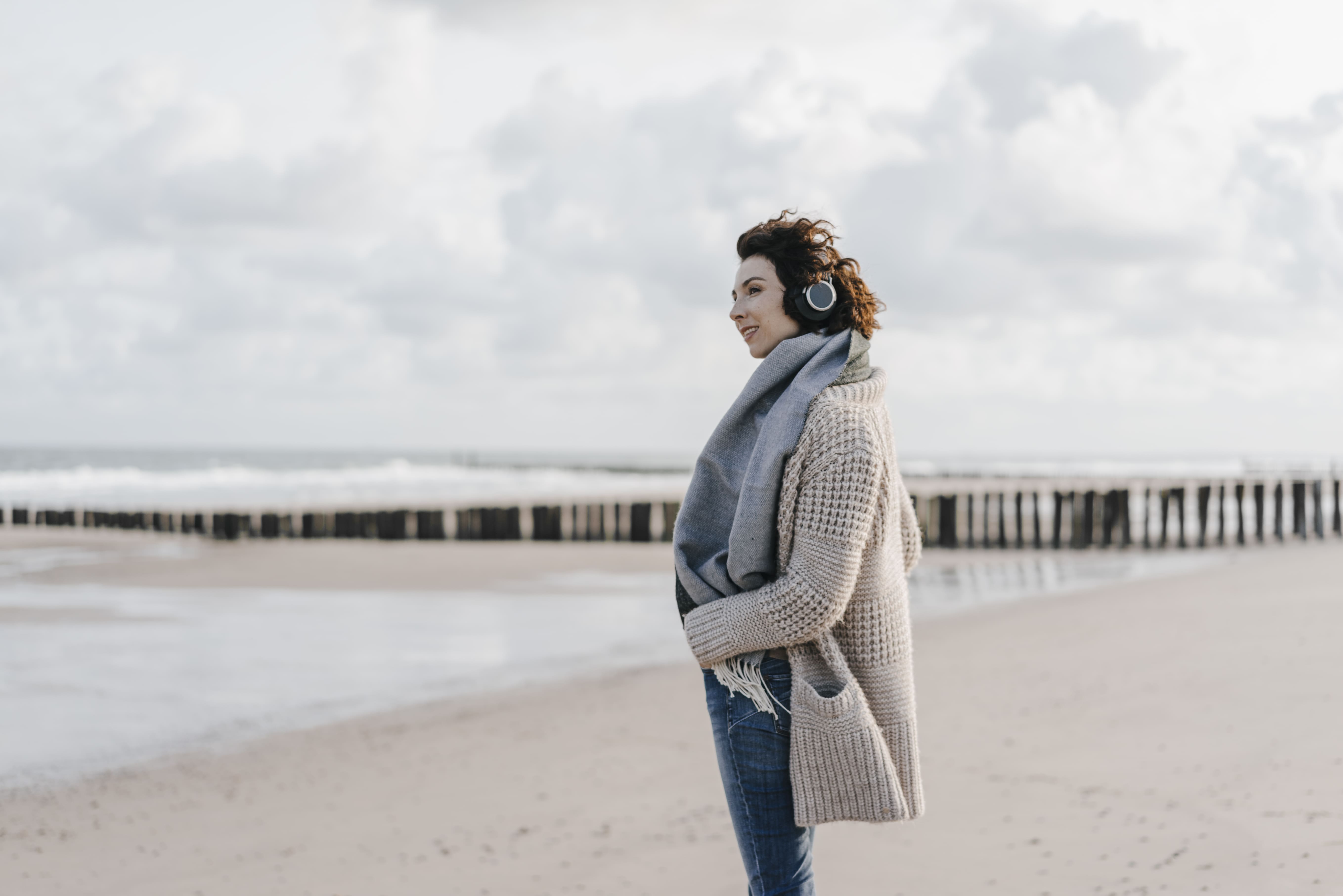 Frau mit Kopfhörern am Strand